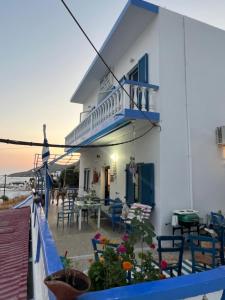 a house with a balcony with a table and chairs at Hotel Glaros Lipsi in Leipsoi