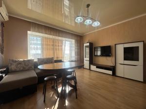 a living room with a table and a couch at 3 комнатная ЖК Альтаир in Aktobe