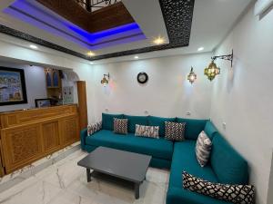 a living room with a blue couch and a table at Dar Syraya in Chefchaouen