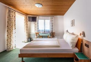 Habitación de hotel con cama y mesa en Gästehaus Erler, en Tux