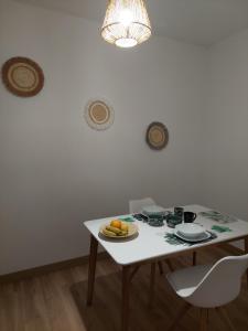 una mesa blanca con un plato de comida. en Vico Holiday Homes 1 Apartman, en Las Medianias