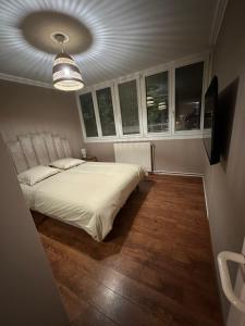 a bedroom with a white bed and some windows at Le Cosy raffiné in Grande-Synthe