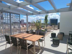 a patio with a wooden table and chairs on a roof at Metrô Studio Alto do Ipiranga in São Paulo