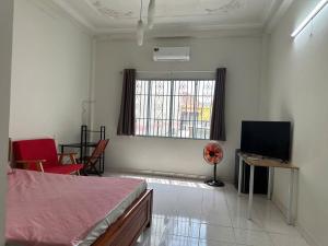 ein Schlafzimmer mit einem Bett, einem Fernseher und einem Tisch in der Unterkunft CoCo home 15 in Ho-Chi-Minh-Stadt