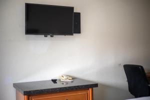 a flat screen tv hanging on a wall at Deluxe Inn in Hayward
