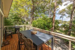 a table and chairs on a deck with a grill at Sunset Palms in Smiths Lake +18 photos