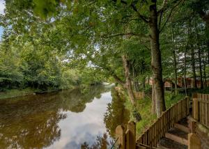 a river with trees and a fence next to it at Gadgirth Estate Lodges in Annbank