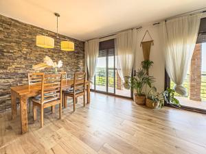 a dining room with a wooden table and a brick wall at Villa Mar & Natura Sitges in Canyelles