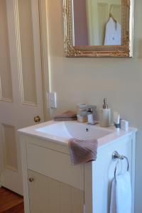 a bathroom with a white sink and a mirror at Oinako Bed & Breakfast in Akaroa +32 photos