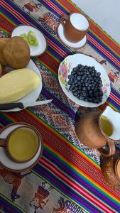 a table topped with plates of food and spoons at Refugio Ecológico Hanan Pacha Granja, Montañas y Aventura in Huaraz