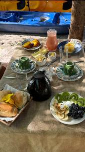 a table with plates of food on a table at Flor da Aldeia Eco Hospedaria in Camaçari +50 photos