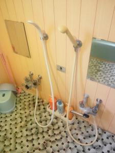 a bathroom with two hoses and a toilet at Mountain Jam in Kutchan