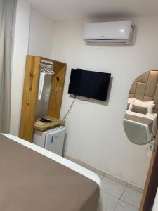 a bedroom with a bed and a sink and a tv at Pousada LuMar Maragogi in Maragogi