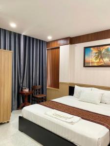 a hotel room with two beds and a chair at Khánh An Hotel in Nha Trang