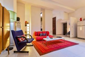 a living room with a red couch and a table at Rome as you feel - Selci Apartment in Rome