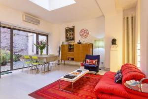 a living room with a red couch and a table at Rome as you feel - Selci Apartment in Rome
