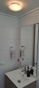 a bathroom with a sink and a large mirror at Montenegro 2 dormitorios in Temuco +5 photos