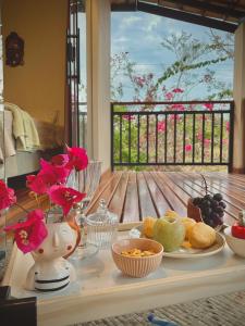 un tavolo con piatti di cibo e fiori sopra di Claruá Chalés - Loft Caju - Romântico & Charmoso em Cavalcante Chap dos Veadeiros a Cavalcante