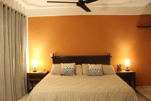 a bedroom with a large bed with two lamps on tables at Comalitas Cafe y Hotel in Comala