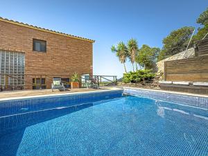 a swimming pool in front of a building at Villa Mar & Natura Sitges in Canyelles