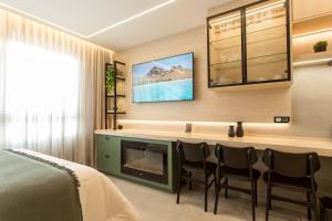 a bedroom with a fireplace and chairs and a bed at Alexa, Piscina, Aconchegante, Netflix, Gym, Vagas in Porto Alegre +36 photos