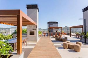 an outdoor patio with tables and chairs on a building at Alexa, Piscina, Aconchegante, Netflix, Gym, Vagas in Porto Alegre