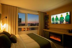 a hotel room with a fireplace and a television at Alexa, Piscina, Aconchegante, Netflix, Gym, Vagas in Porto Alegre