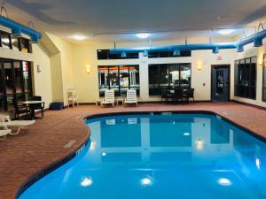a large swimming pool with blue water in a building at Comfort Suites Plymouth near US-30 in Plymouth