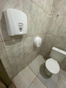 a bathroom with a toilet and a paper dispenser on the wall at Toca do Bola in Sao Jose do Rio Preto +12 photos