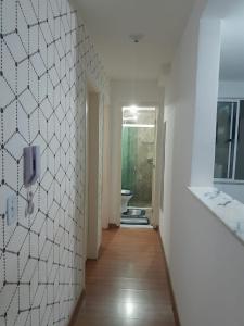 a hallway of a bathroom with a sink and a toilet at Lar feliz in Juiz de Fora