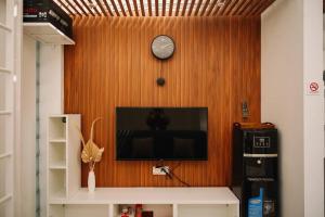 Batureo 1Hibearnation Villa near Lembang Zoo的墙上有电视和时钟