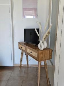 a television on a wooden table in a room at MilosBluePearl in Triovasálos