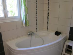 a bath tub with a faucet in a bathroom at Maison confortable avec animaux acceptés et jardin clos - FR-1-489-552 in Ferrières-sur-Sichon