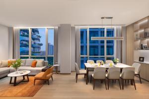 a living room with a table and chairs and a couch at Somerset QPlex Shenzhen in Shenzhen