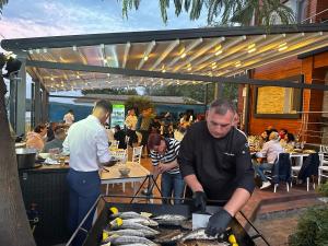 a man cooking fish on a grill at a restaurant at Casa Teo in Mahmudia