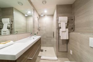 a bathroom with a sink and a shower at Residence du Parc - Luxury Apartment in Queenstown +8 photos