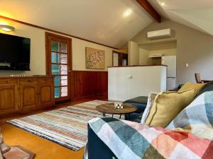 a living room with a couch and a refrigerator at Karri Glade Farm Stay in Glenoran