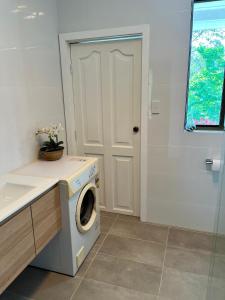 KurrajongMountain View Blue Mountains的门旁浴室里的洗衣机和烘干机 更多15张照片