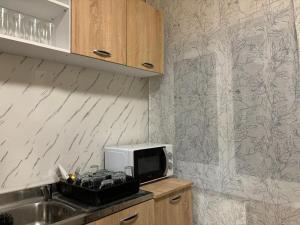 a kitchen with a microwave on top of a counter at Vila Eden Azuga in Azuga