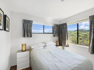 una camera da letto bianca con un letto e due finestre di Fab 3-Bed Stay with Great Outdoors & Water Views a Surf Beach
