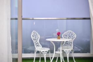 two chairs and a table with a vase on it at Cameron Palas Homestay - Sunrise View in Brinchang