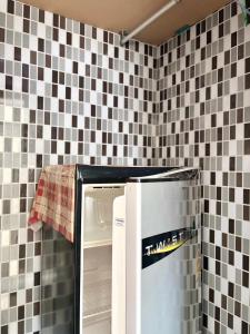 a refrigerator in a kitchen with black and white tiles at LSN Mansion in Bangkok +18 photos