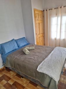 a bedroom with a large bed with a blue couch at Cabaña en Volcan in Volcán