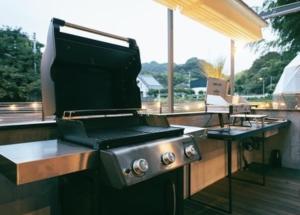a bbq grill on a deck with a table at ODEON Gongen松山市一組限定貸切グランピング in Horiechō