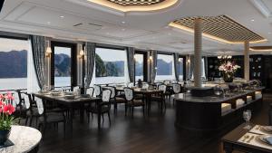a dining room with tables and chairs and windows at Majesty Luxury Prime Cruise by Premier Group in Ha Long
