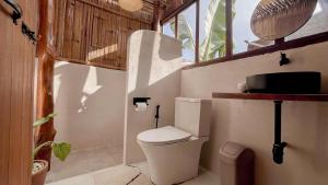 a small bathroom with a toilet and a window at ซือรี ก๊ะฉิ - Suri Kachi ที่พักดอยช้าง in Ban Huai Khai