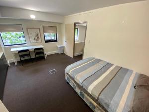 Un dormitorio con una cama y un escritorio. en Lily's Cosy Room,Traveler Friendly, en Perth