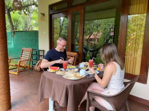 a man and woman sitting at a table eating food at Alone Cage Ella in Ella +14 photos