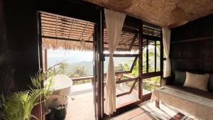 a room with a window with a view of a mountain at ซือรี ก๊ะฉิ - Suri Kachi ที่พักดอยช้าง in Ban Huai Khai