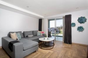 una sala de estar con un sofá y una mesa en Nautica 410 by Mountain City Investments, en Mossel Bay